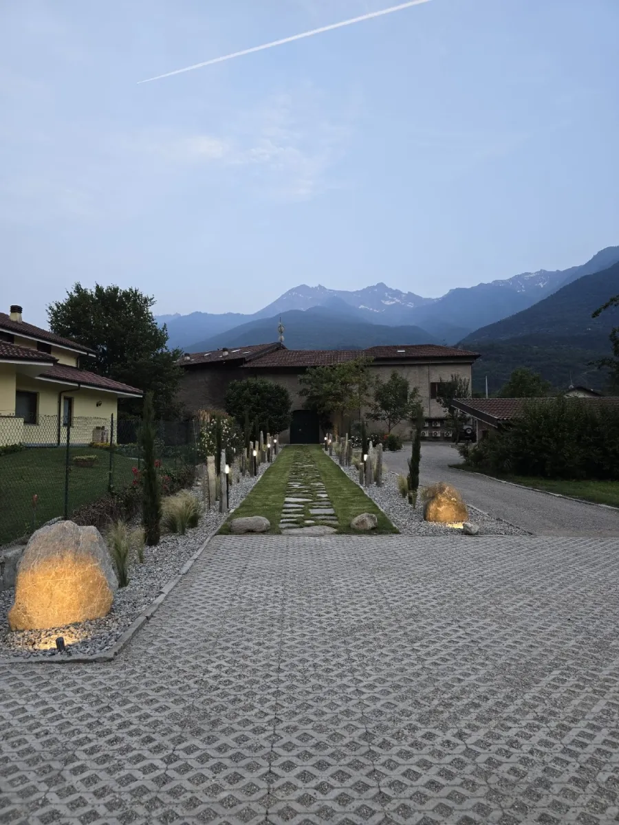 Viale d'ingresso con pavimentazione in prato e passi persi in lose, menir in pietra e cipressi