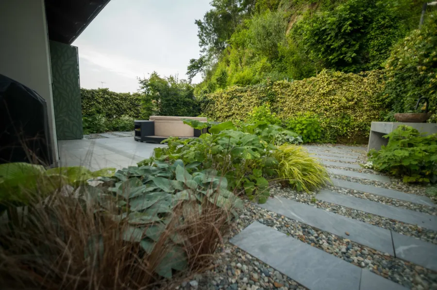 Passi persi su ghiaia in giardino ombroso con bordura mista